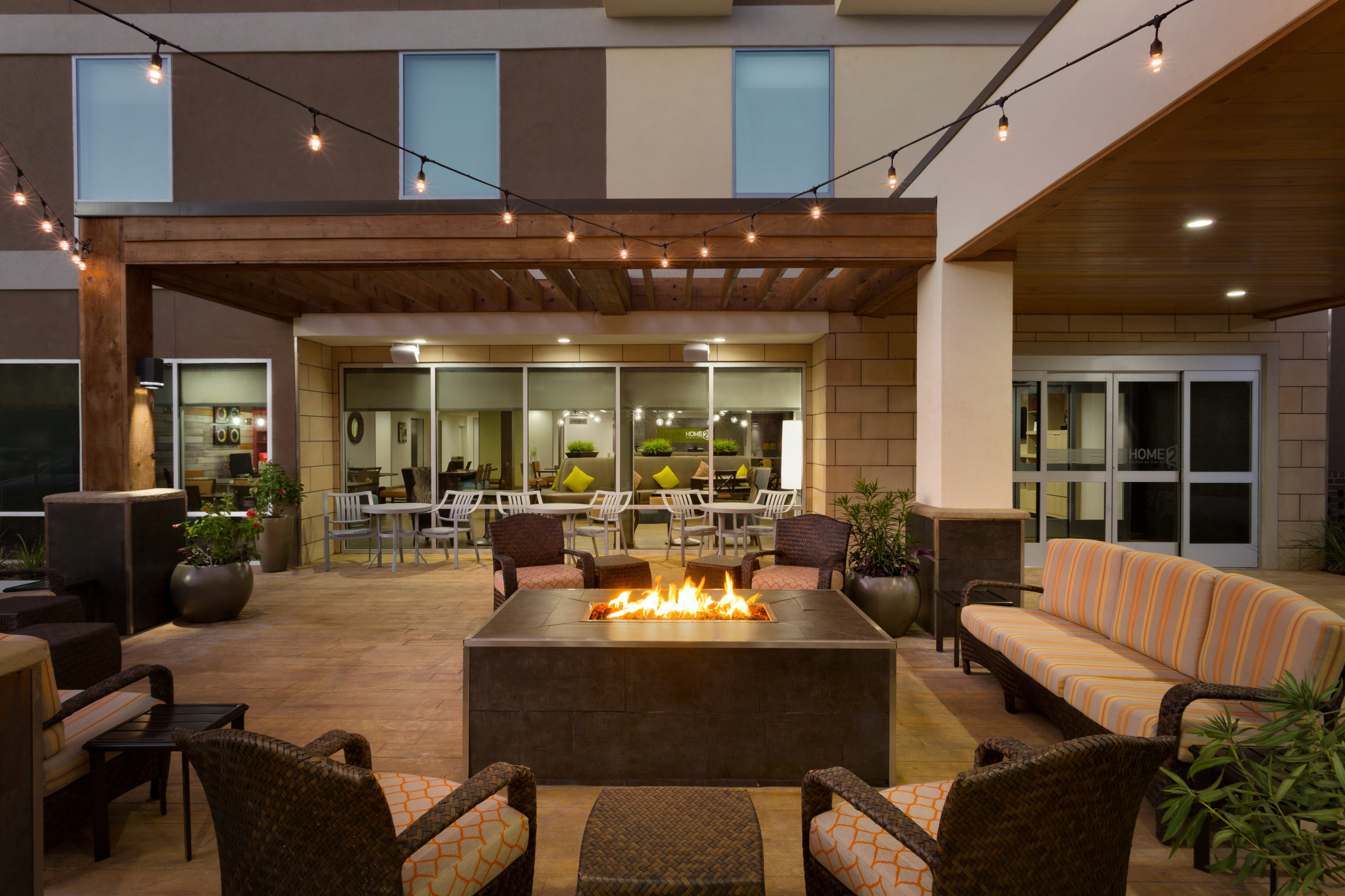 Outdoor Patio Area with Firepit, Armchairs and Sofa at Night